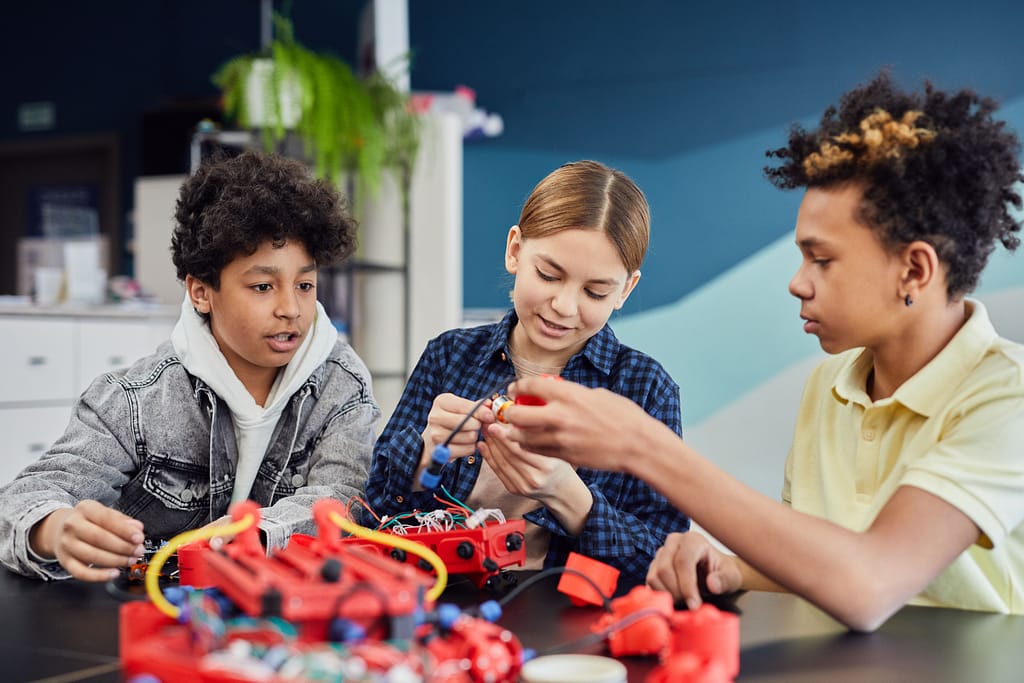 Three kids working on a project, creating something. Project Based Learning